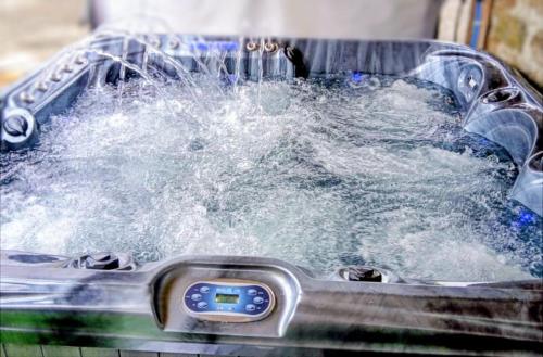 a hot tub filled with boiling water with aperature at Tomnauld Farm Wellness Cottage in Pitlochry