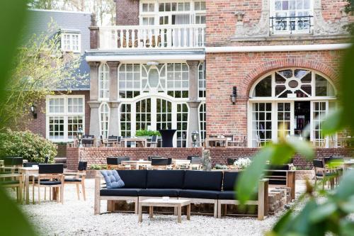 a blue couch in front of a brick building at Kasteel Kerckebosch in Zeist