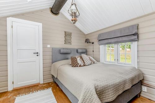 ein Schlafzimmer mit einem Bett und einem Fenster in der Unterkunft Family-Friendly Log Cabin With Panoramic View in Østby
