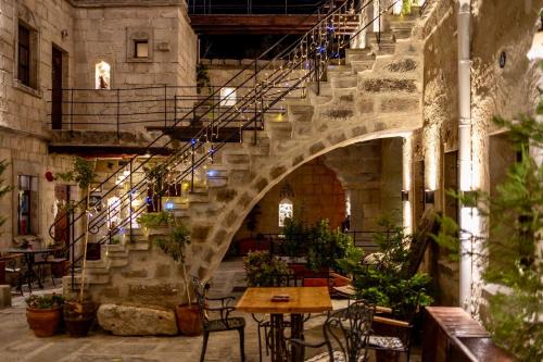 a staircase in a building with a table and chairs at Century Cave Hotel in Goreme