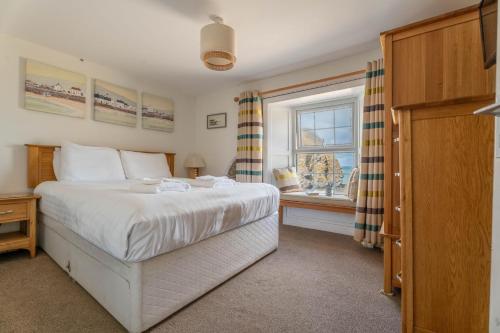 a bedroom with a bed and a window at Trem y Don at Llangrannog Beach in Llangrannog
