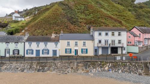 a row of houses on the side of a hill at Trem y Don at Llangrannog Beach in Llangrannog