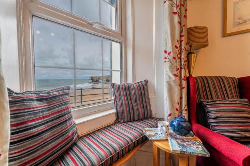 a living room with two chairs and a window at Trem y Don at Llangrannog Beach in Llangrannog