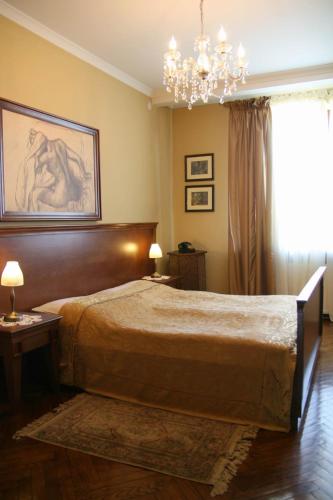 a bedroom with a large bed and a chandelier at Dom Retro Pivnica in Jastrzębie Zdrój