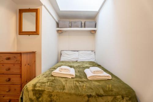 a small bedroom with a bed with towels on it at Trem y Don at Llangrannog Beach in Llangrannog