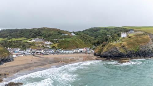 an aerial view of a beach with houses and the ocean at Trem y Don at Llangrannog Beach in Llangrannog
