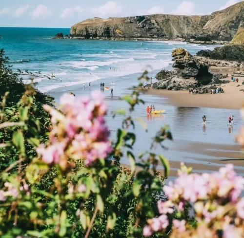 a view of a beach with people in the water at Trem y Don at Llangrannog Beach in Llangrannog