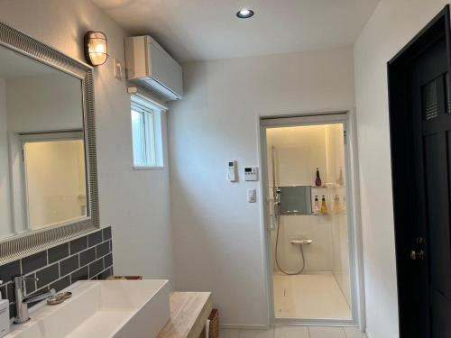 a white bathroom with a sink and a shower at NAGAHAMA lifestyle glamping hotel in Nagahama
