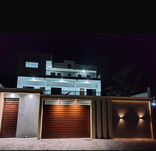 a building with two garage doors at night at Mansão Essência Pipa in Pipa