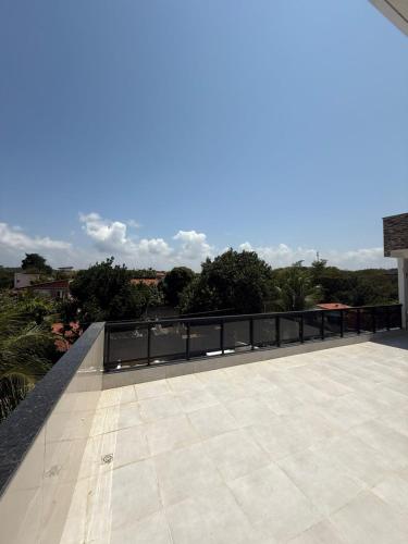 a view of a patio with a fence and trees at Mansão Essência Pipa in Pipa