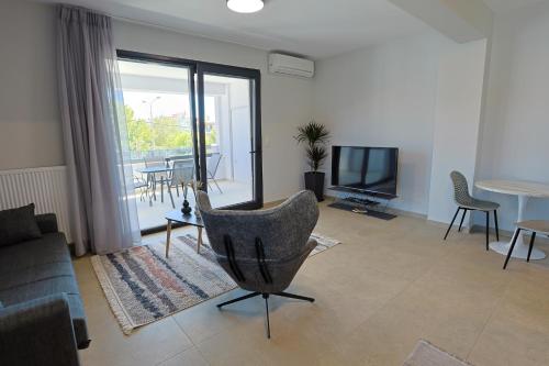 a living room with a couch and a television at Isol Rooms A1 in Katerini