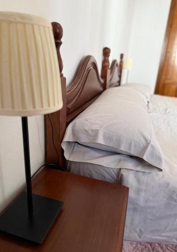 a lamp on a table next to a bed at Hotel Rural Palacete de Mañara in Montejaque