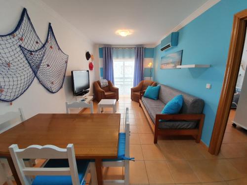 a living room with a couch and a table at Casa T2 in Monte Gordo
