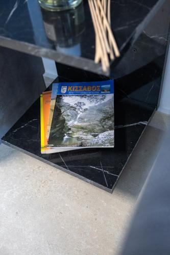 a book sitting on top of a black table at Isol Rooms A1 in Katerini