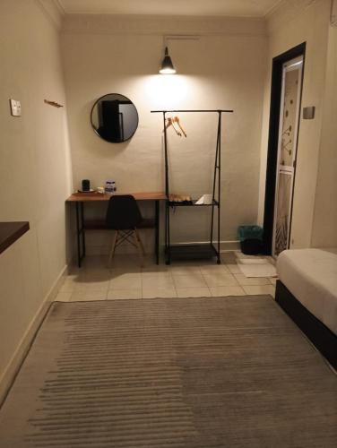 a room with a desk and a bed and a mirror at Andiana Hotel & Lodge - Kota Bharu City Centre in Kota Bharu