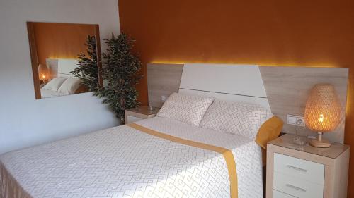 a bedroom with a white bed and a mirror at CALELLA DE LA COSTA ( Maresme - Costa Brava) in Calella