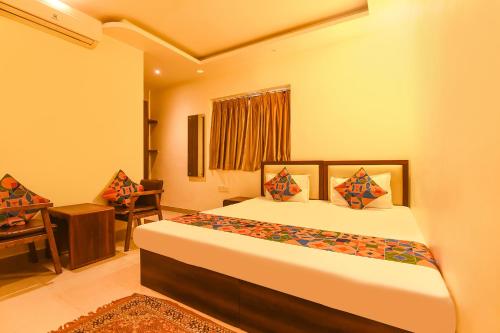 a bedroom with a bed and a desk and a chair at Super Collection O Motisarai in Kolkata