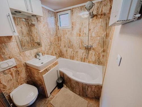 a bathroom with a tub and a sink and a toilet at Holiday home Pandora in Brežice