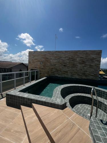 una piscina en la parte superior de un edificio en Flat com Hidromassagem Privativa no Centro De Porto de Galinhas - Sol e Mar Residence, en Porto de Galinhas