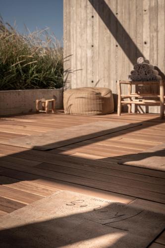 a wooden deck with a chair and a building at Theros All Suite Hotel - Adults Only in Kos Town