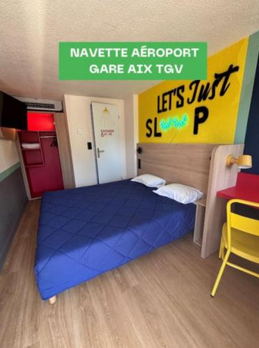 a bedroom with a blue bed in a lego room at Première Classe Aéroport Marseille in Vitrolles