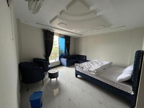 a bedroom with a bed and chairs in a room at askari lodges in Murree