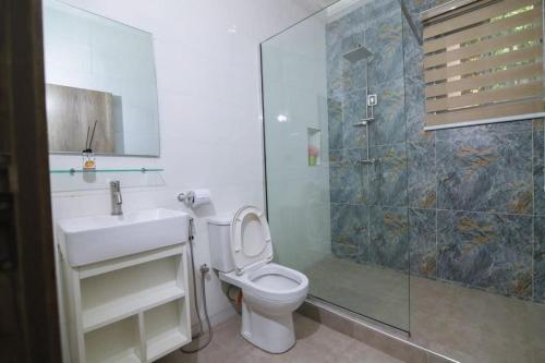 a bathroom with a toilet and a sink and a shower at Fort Fountain Apartments in Abuja