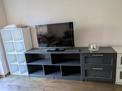 a black entertainment center with a flat screen tv on top at Modern Apartment in Sofia Near City Center in Sofia