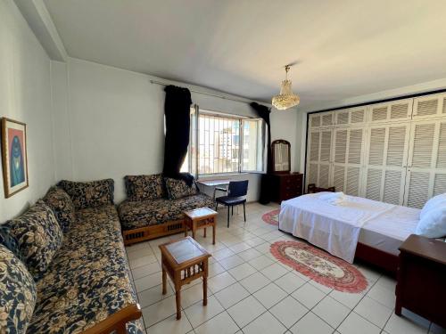 a living room with a bed and a couch at Luxury appartement centre ville Fes - French Touch in Fès