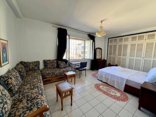 a living room with a bed and a couch at Luxury appartement centre ville Fes - French Touch in Fès