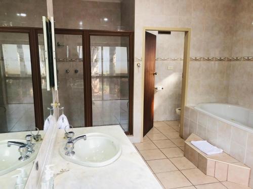 a bathroom with two sinks and a bath tub at Grafiti Boutique Hotel in Bela-Bela