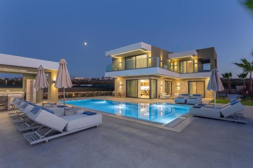 a house with a swimming pool in front of it at Divel Luxury Villas with heated pools, by Estia in Anissaras
