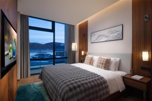 Postel nebo postele na pokoji v ubytování Oakwood Suites Chongli