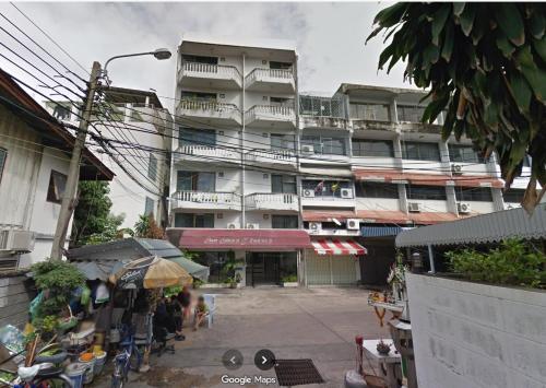 a large apartment building with a market in front of it at BaanSathorn21 in Bangkok