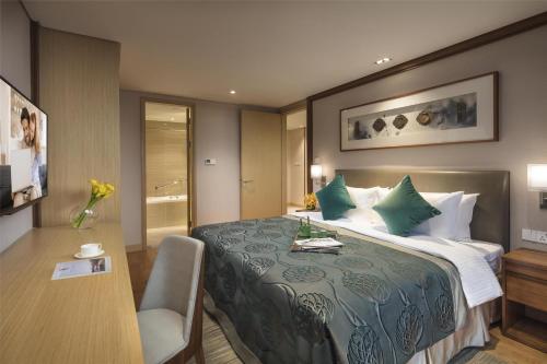 a hotel room with a bed and a desk at Somerset Baitang Suzhou in Suzhou