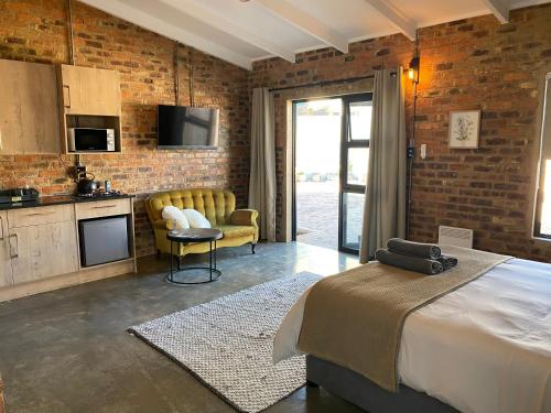 a hotel room with a bed and a kitchen and a kitchen at MK & R Guesthouse in Alberton