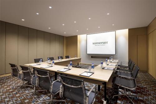 a conference room with a long table and chairs at Somerset Baitang Suzhou in Suzhou