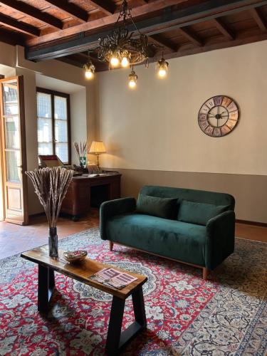a living room with a green couch and a table at Dimora 1848 - Foresteria Lombarda in Volta Mantovana