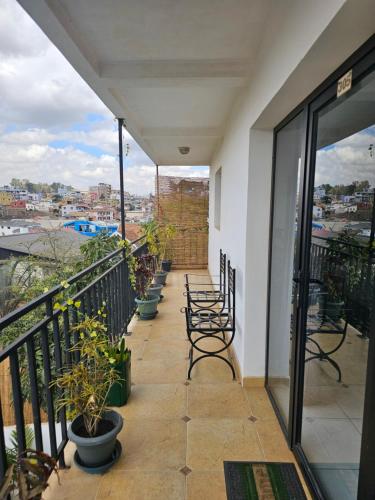 a balcony with chairs and potted plants at La Casa Di Luna - Hotel with Pool and Restaurant in Antananarivo in Antananarivo
