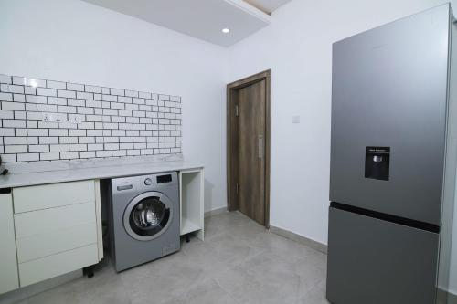 a laundry room with a washing machine and a washer at Fort Fountain Apartments in Abuja