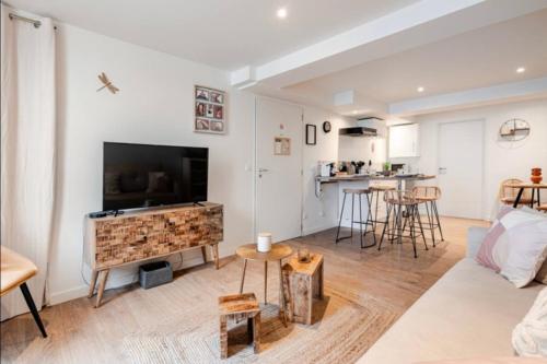 a living room with a flat screen tv and a couch at L'échappée Belle in Vienne