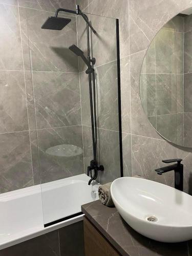 a bathroom with a sink and a glass shower at Dreams home in Uzhhorod