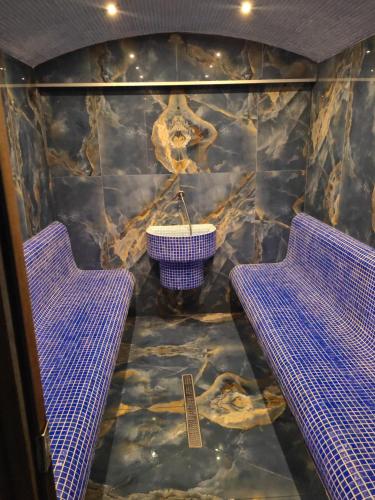 a room with two purple benches and a rock wall at Вилно селище PARADISE VIEW in Sarnitsa
