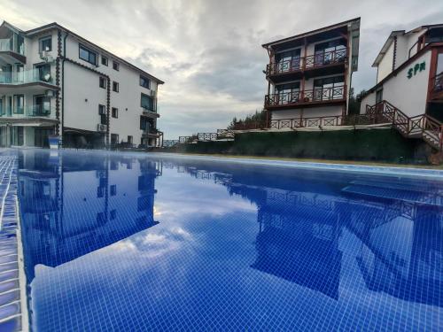a swimming pool in front of some buildings at Вилно селище PARADISE VIEW in Sarnitsa