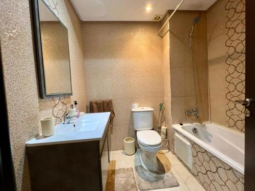 a bathroom with a toilet and a sink and a tub at Apartment Casa Marina - Borgone, Ocean & Hassan II Views in Casablanca