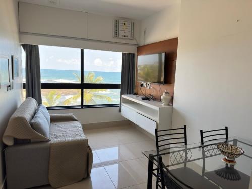 a living room with a view of the ocean at Ondina Apart Hotel Residences in Salvador