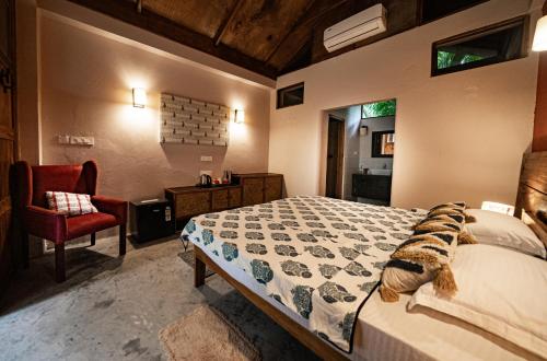 a bedroom with a bed and a chair and a window at Dancing Dugong in Neil Island