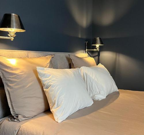 a group of pillows on a bed with two lamps at Hotel Saint Georges in Mons