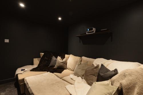 a black room with a couch with pillows on it at Luxury 3 Bed Home Near Peak District with Cinema Room in Mossley