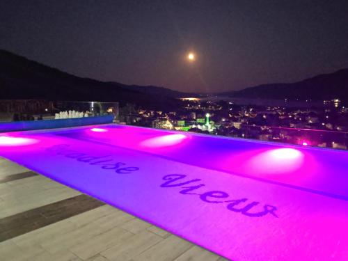 a lit up pool on a roof at night at Вилно селище PARADISE VIEW in Sarnitsa